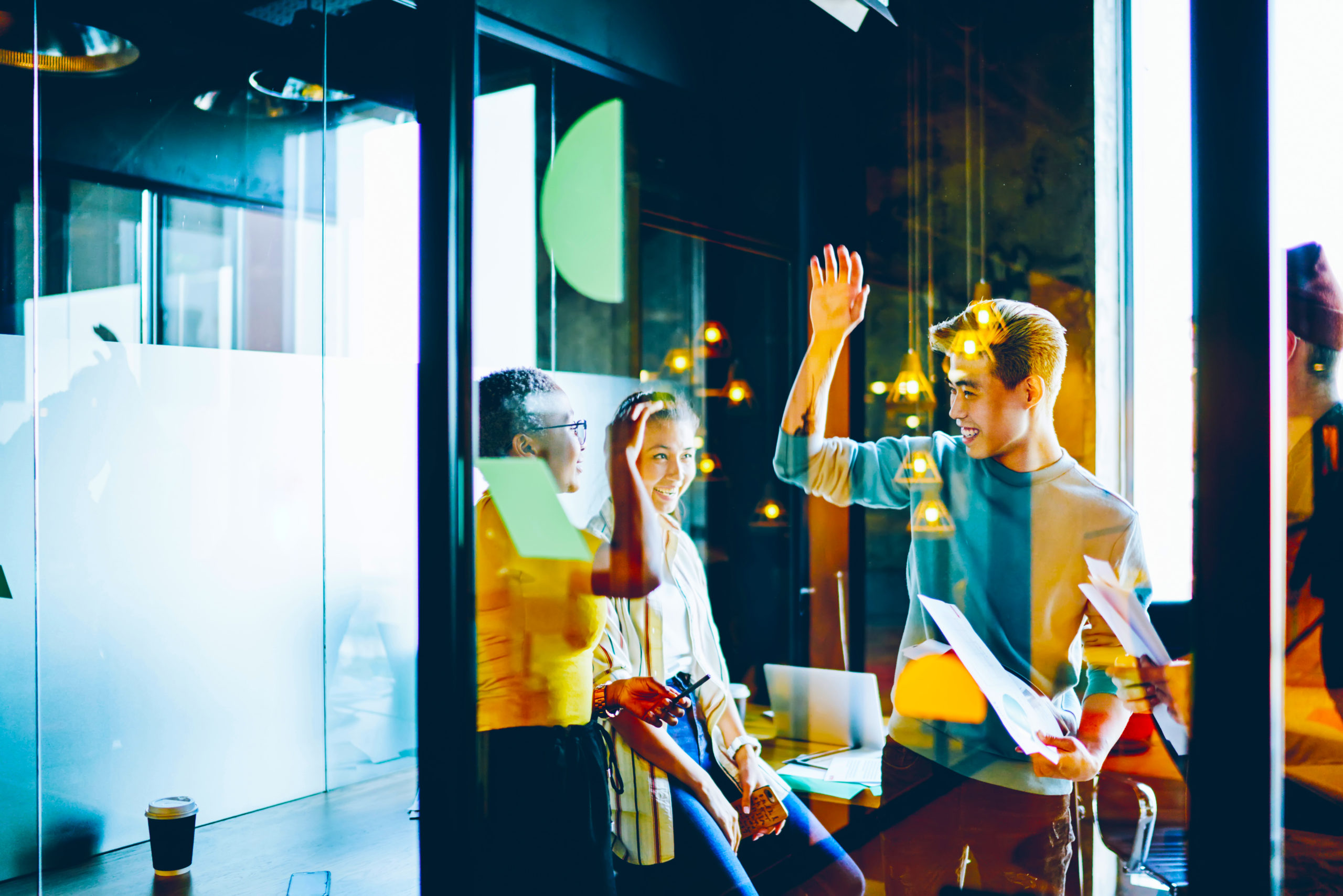 Happy young male and female employees accomplished project planning together giving high five gesture, skilled multiracial crew of satisfied with productive cooperation in coworking office.